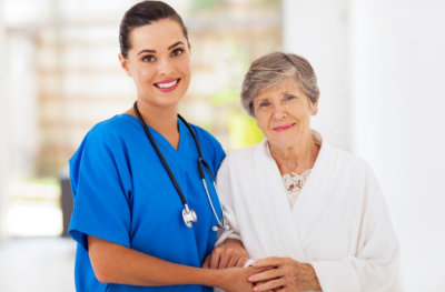 senior woman and nurse smiling