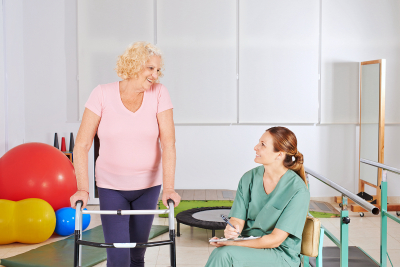 elderly woman with walker in physical therapy in nursing home