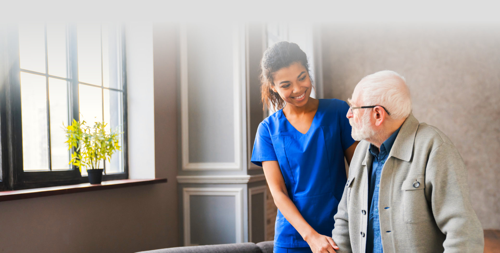 caregiver assisting senior man smiling