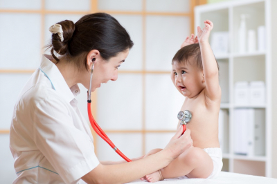 female nurse examining heartbeat of a child with a stethoscope
