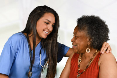 female nurse and senior woman smiling