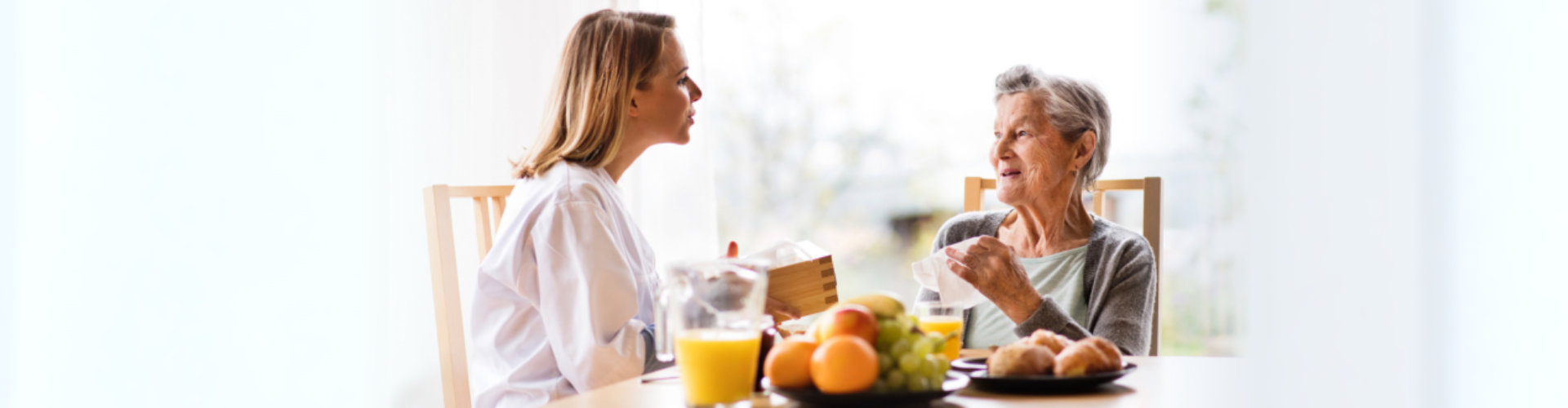 physicians talking to senior woman about nutrition and diet adjustments with healthy foods in the table