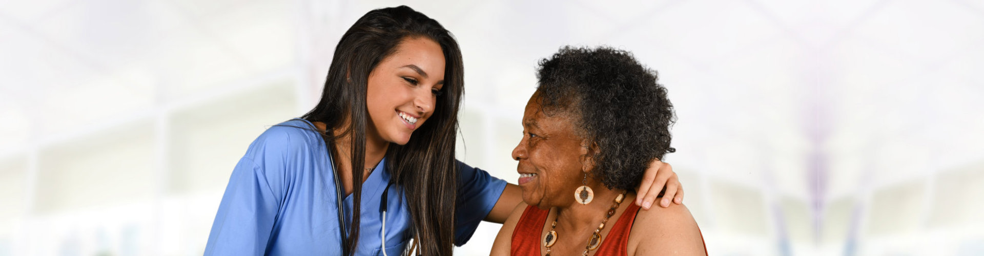 female nurse and senior woman smiling