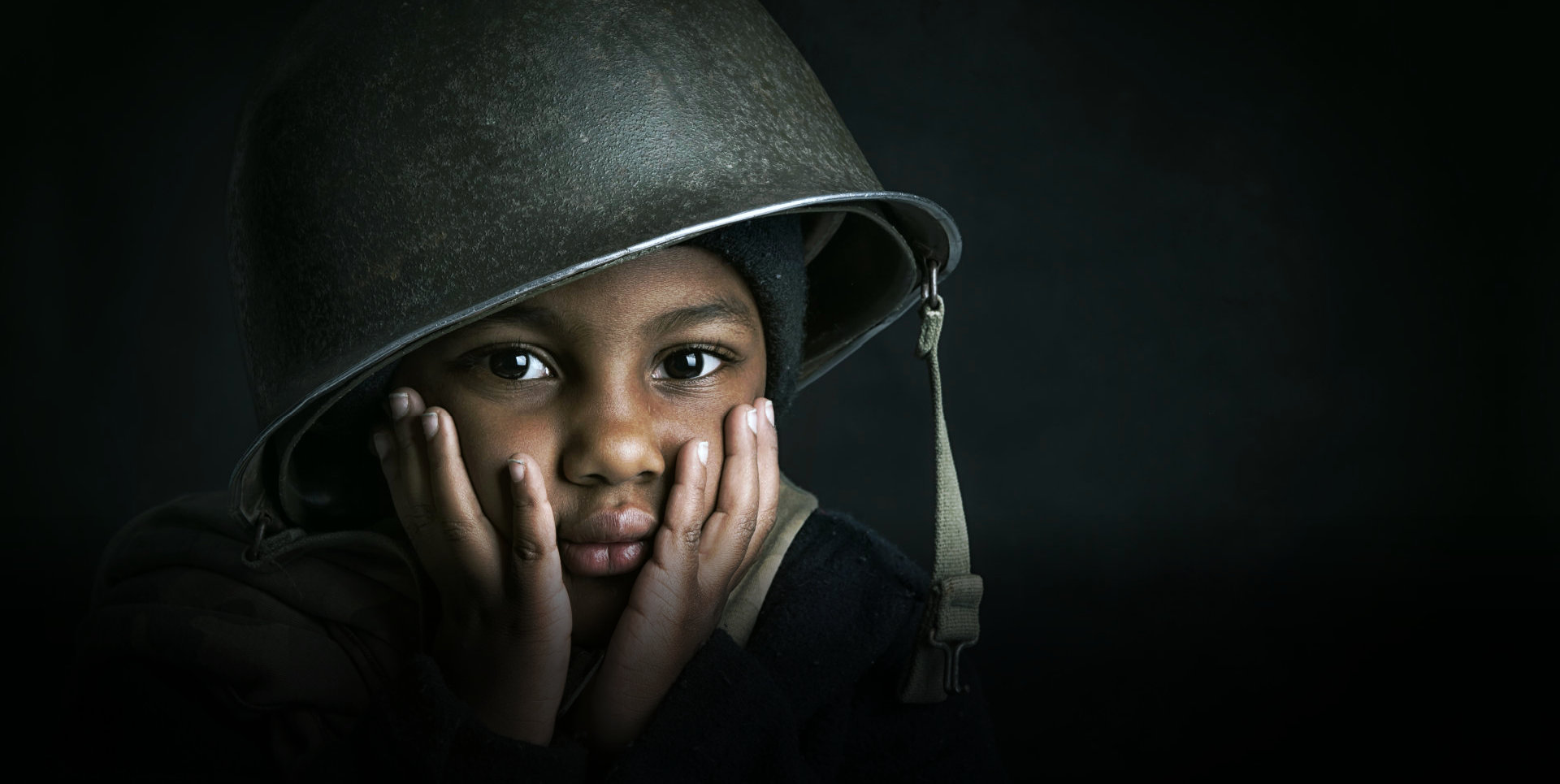 kid wearing a solider's helmet