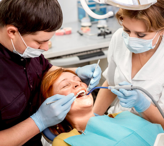  Dentist with assistant examining implants teeth