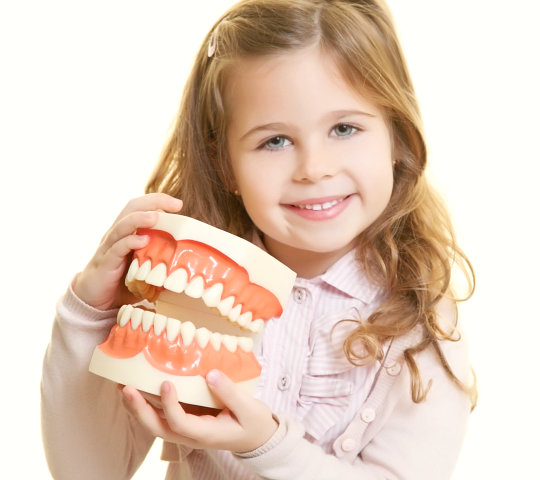 Happy smiling girl with dentist tool