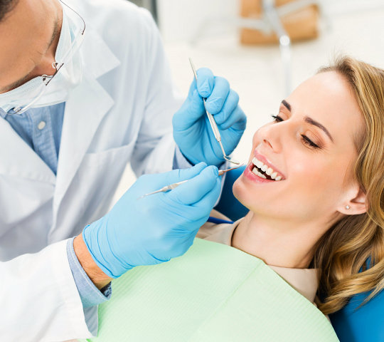 Doctor treats patient teeth in modern dental clinic