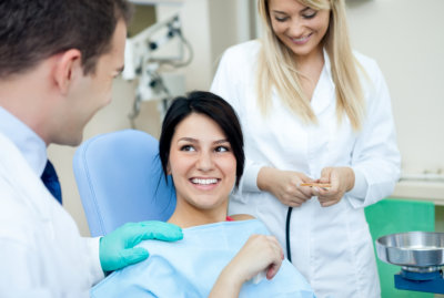 Male dentist, his assistant and female patient